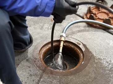 Image of a plumber performing a hydro jetting on a drain